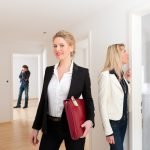 Estate agent showing modern property to potential buyer – illustrating benefits of property scenting for real estate marketing